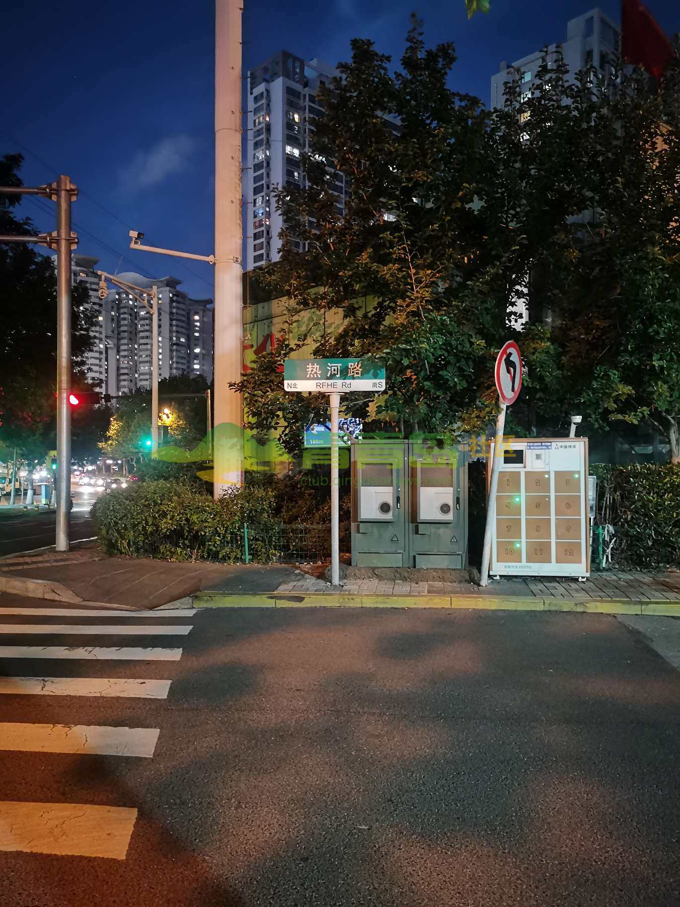 热河路公共厕所指示牌被路名牌和树叶遮挡,影响市民,游客查看